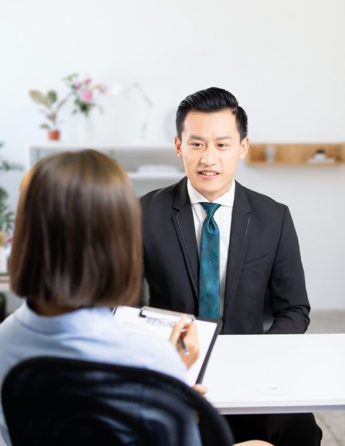 a woman interviewing a man in a black suit - What Recruiters Look for in Chat Job Applicants